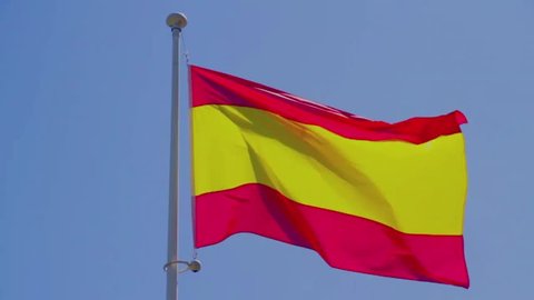 Civil, commercial Spain flag without coat of arms to blue sky, slow motion