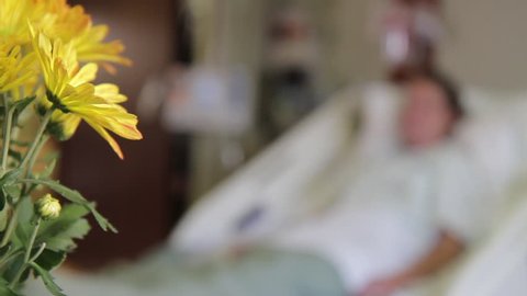 Medical-hospital patient with flowers. Patient out of focus.