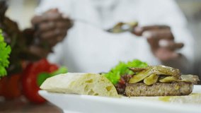 4K clip. A delicious gourmet burger is given the finishing touches by the chef in a restaurant or hotel kitchen, 