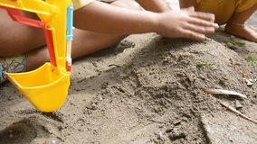 boy playing with toy backhoe and sand on ground, Dolly shot HD 1080 video footage
