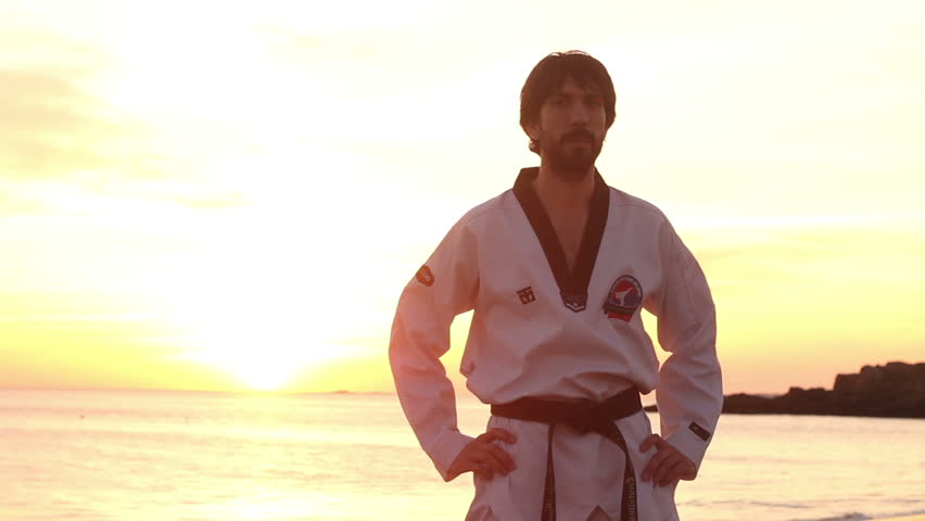 Silhouette of sport student exercising martial arts in beach. Panoramic skyline view.
