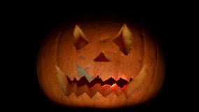 Halloween pumpkin. Flickering red light between teeth