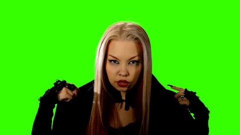 Female vampire removes the black veil on green screen. Halloween.