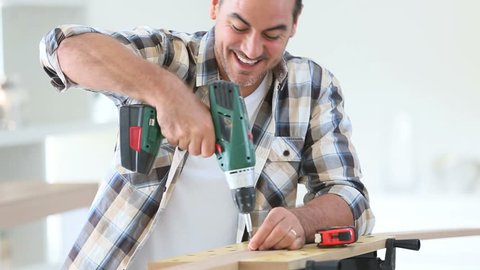 Man at home using electric drill