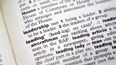 Yellow highlighter pen highlights 'Leadership' in dictionary