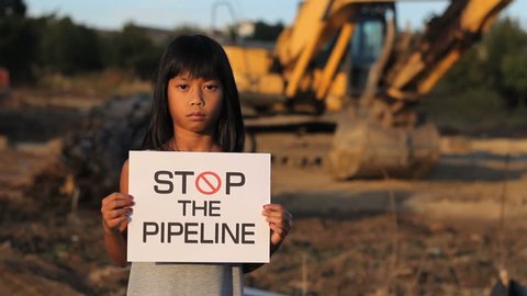 A young First Nations girl proactively demonstrates against the proposed oil pipeline running through her province in Canada.