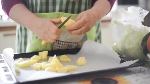 close up of woman housewife hands cooking baked potatoes