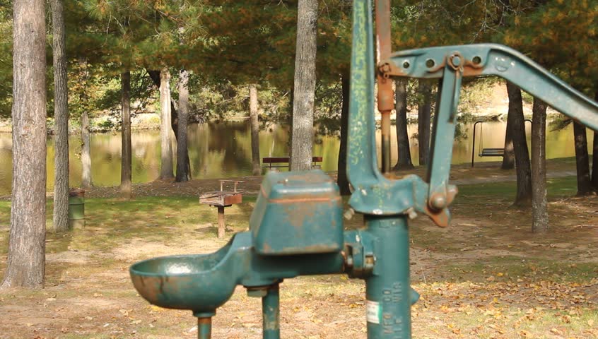 vintage hand water pump being pumped to get water