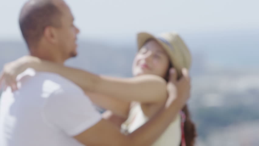 Romantic couple share a kiss with city view in the background