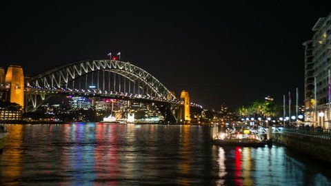 Reflections of the city lights in the water of Sydney Harbour wide shot