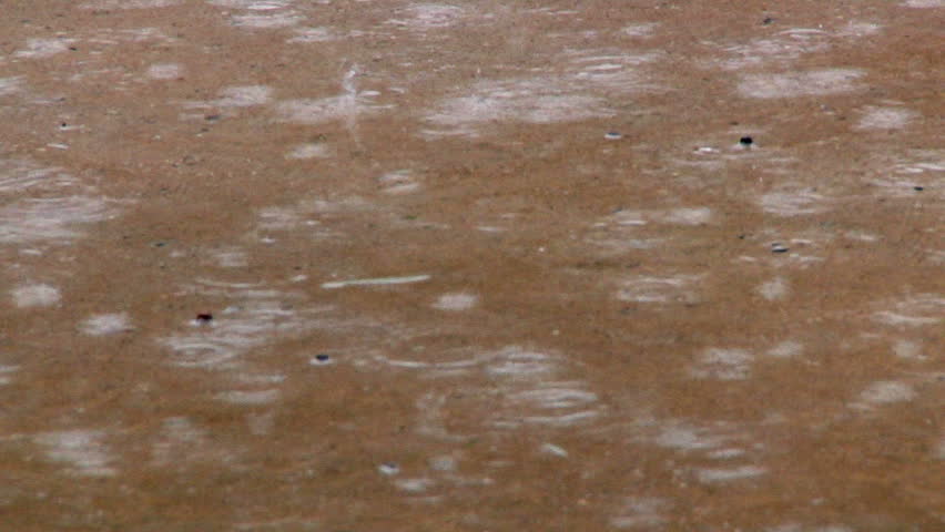 Raindrops falling on a wet sidewalk.  Shot at 60fps.
