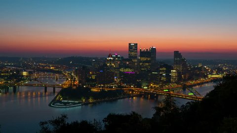 (Time-lapse/Zoom-in) Morning twilight transitions to sunrise over Pittsburgh, Pennsylvania including the skyline, bridges and Point State Park at the confluence of the Allegheny and Monongahela Rivers
