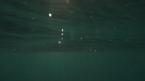 Calm sea surface in slow-motion from underwater with sun rays going through. Shot on RED Cinema Camera in 4K, crop, rotate and zoom easily. H264 codec High bit rate.