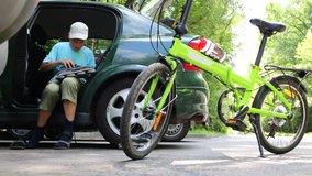 Boy gets ready to ride on roller skates in car next to bike