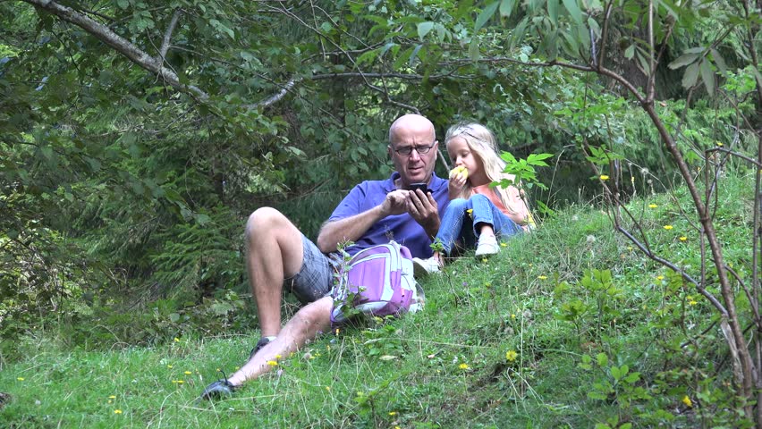 4K Happy Family Using, Playing on Smartphone, Mobile, Father and his Daughter Resting on a Mountain Path, Trail in Forest, Child Eating Apple Fruit Outdoor, People in Summer Vacation, Trip