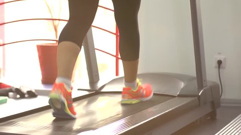 Sport woman legs on treadmill in gym