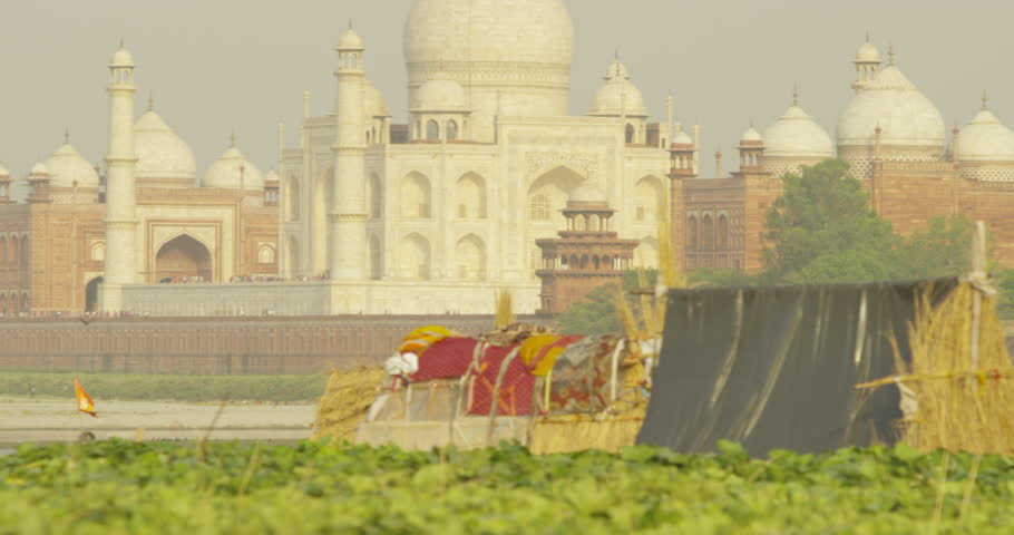 AGRA - April 6, 2014: Kakri (Indian Cucumber), and Ghiya (Bottle Gourd) farmers work with the Taj Mahal as their backdrop.