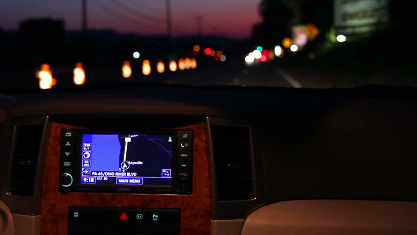 A man adjusts his in-dash GPS during a night drive. MAY BE SUITABLE FOR