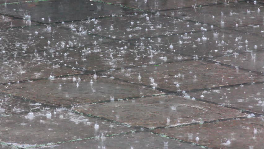 heavy rain drops on the pavement
