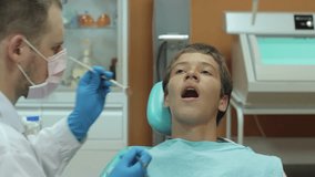 Dentist carry out routine inspection of the mouth of a boy video close-up