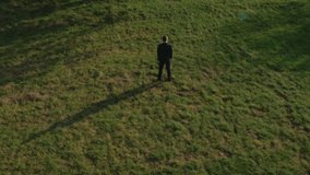 Businessman standing next to a lonely tree