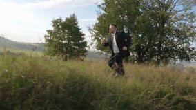 Businessman running on summer meadow