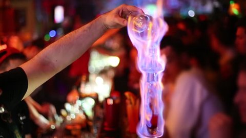 Burning cocktail, barmen and visitors in new bar of night club