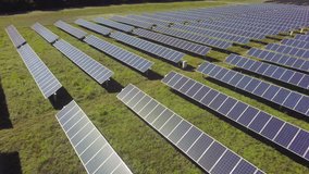 Aerial view flying over solar panels, sun shining back at camera stock video footage clip