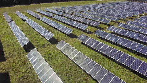 Aerial view flying over solar panels, sun shining back at camera stock video footage clip Stockvideó