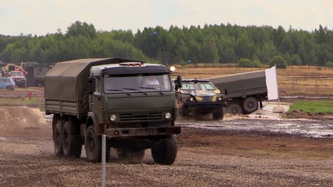 Zhukovsky. Russia. 17 aug 2014: Oboronexpo 2014. Exhibition of arms. Three army vehicles KAMAZ overcomes the pond at military training ground