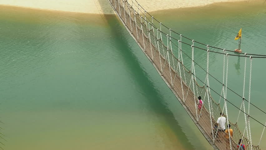 People walk across suspension bridge
