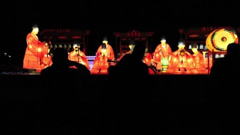 Taipei, Taiwan-24 February, 2013: Light up celebrating lantern festival, Timelapse Musicians in traditional costume lanterns in the Taipei Light Festival, silhouette people walking -Dan