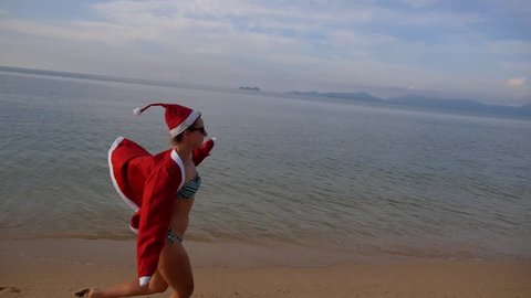 Sexy Woman in Santa Hat and Bikini Running on Sea Beach. Christmas and New Year on the Samui Tropical Island, Thailand. Slow Motion. HD, 1920x1080.