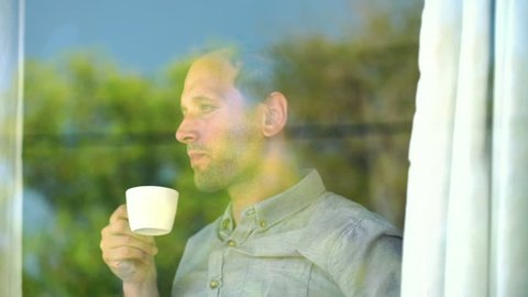 Young man enjoying morning coffee by the window
