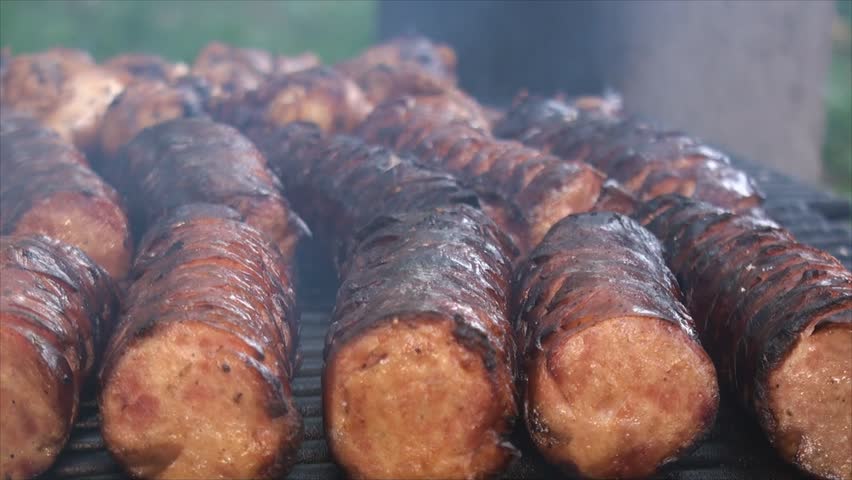Polish sausages pieces scorching on the fire pit
