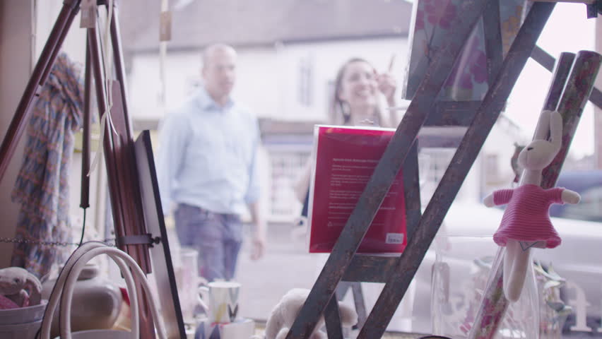 Customers browsing and shopping in local gift store. Purchasing products and goods from shop keeping in small business store.