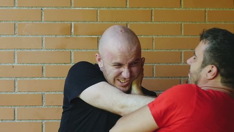 two men fighting with hands on their faces: quarrel, fight, conflict. Slowmotion
