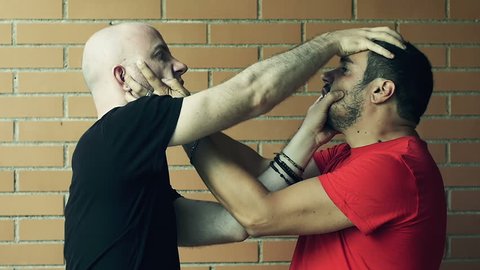 two men fighting against a wall: fight, quarrel. Slowmotion