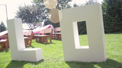 large letters LOVE on the grass on wedding
