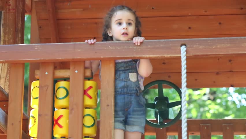 Little girl with braids is playing on tic-tac-toe and rope.