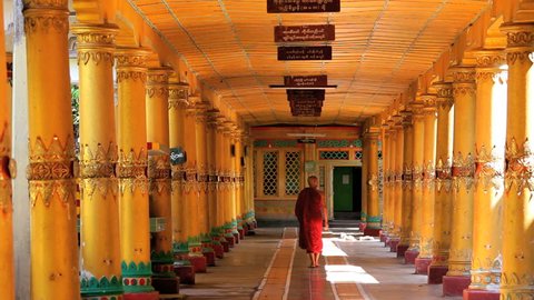 Monk in traditional dress in walkway Kha Khat Wain, Kyaung Monastery, Bago, Asia