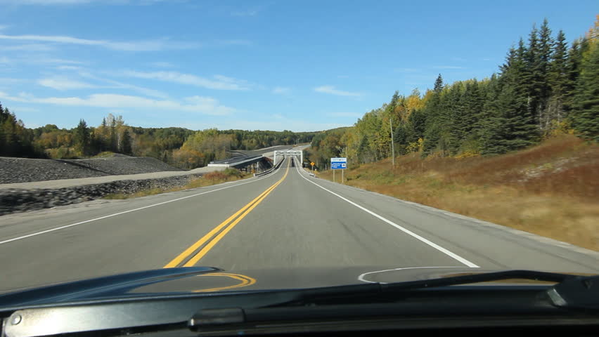 Driving across a truss bridge that crosses the Pic River. Footbridge on right and bridge under construction on left. Trans Canada HWY No 1 or Hwy ON-17 in Northern Ontario, Canada.