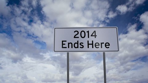 Road side highway sign with the message that the 2014 is ending and the 2015 new year is coming up soon with a timelapse clouds background.