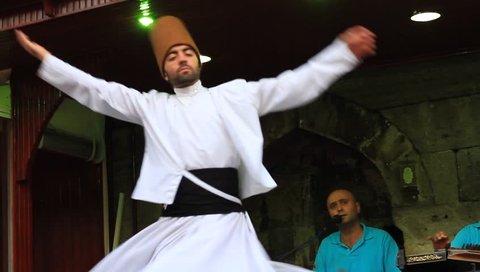 ISTANBUL - JUL 25, 2012: Sufi whirling dervish (Semazen) dances at Sultanahmet during holy month of Ramadan.Semazen conveys God's spiritual gift to those are witnessing ritual. He spins with the music