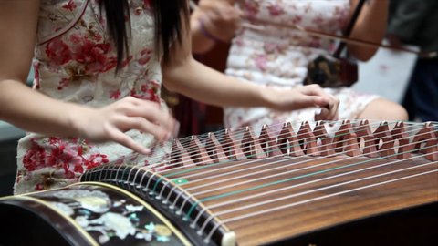 Chinese traditional musician playing chinese guzheng.Guzheng, also called zheng or Chinese plucked zither,is a plucked half-tube zither with movable bridges and  strings. 