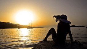 silhouette girl with straw hat watching sunset and boat at sea, STOCK VIDEO