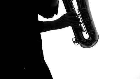 Close up of dark silhouette of musician playing the saxophone