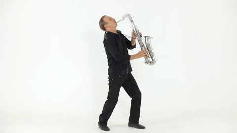 Man in dark shirt and trousers playing the silver saxophone