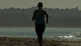 Female running on beach HD Slow motion sihouette