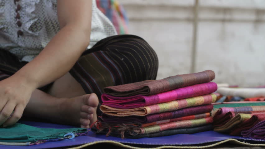 lady folding silk in Lao